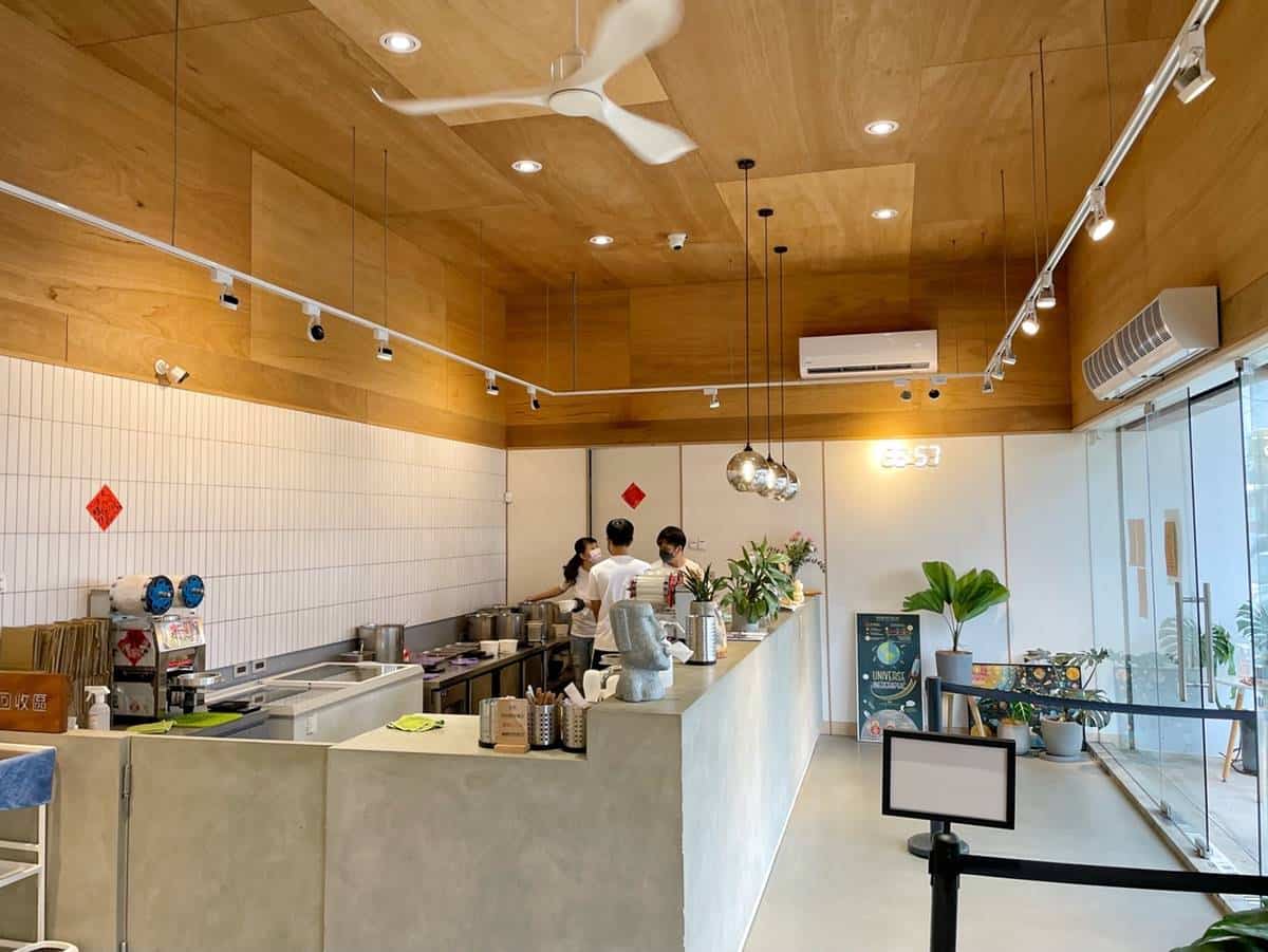 澎湃豆花龍潭總店的外觀是半鐵皮屋打造的白色建築；裡面裝潢是簡約的木質文青風。（圖／阿華田的美食日記提供）