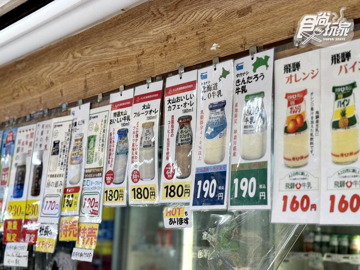 店面掛著一整排牛奶品種價目的牌子,幾乎囊括了日本全國知名牛奶。(圖/陳倍玉攝)
