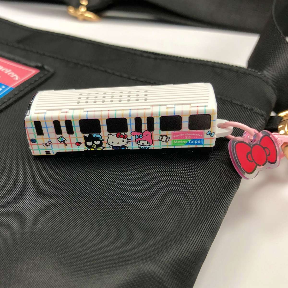 紅色蝴蝶結是吊飾掛鉤,嗶卡時不僅會發出「Hello Kitty、Hello Kitty」的聲音,車頭還會亮燈。(圖/台北捷運提供)
