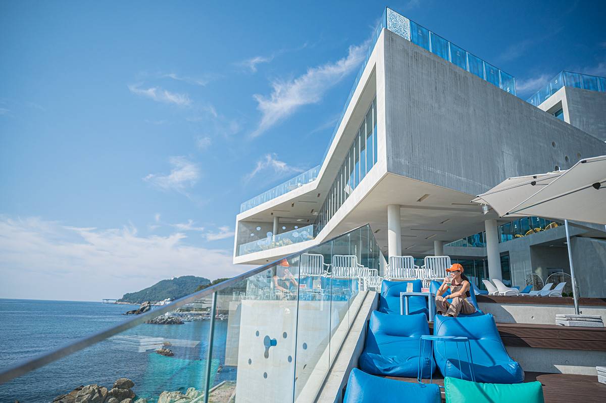 釜山這間「CORALANI」看海咖啡廳設計風格，將建築物融入海岸與山巒景致中，共有４層樓的空間。（圖／焦糖熱一點提供）