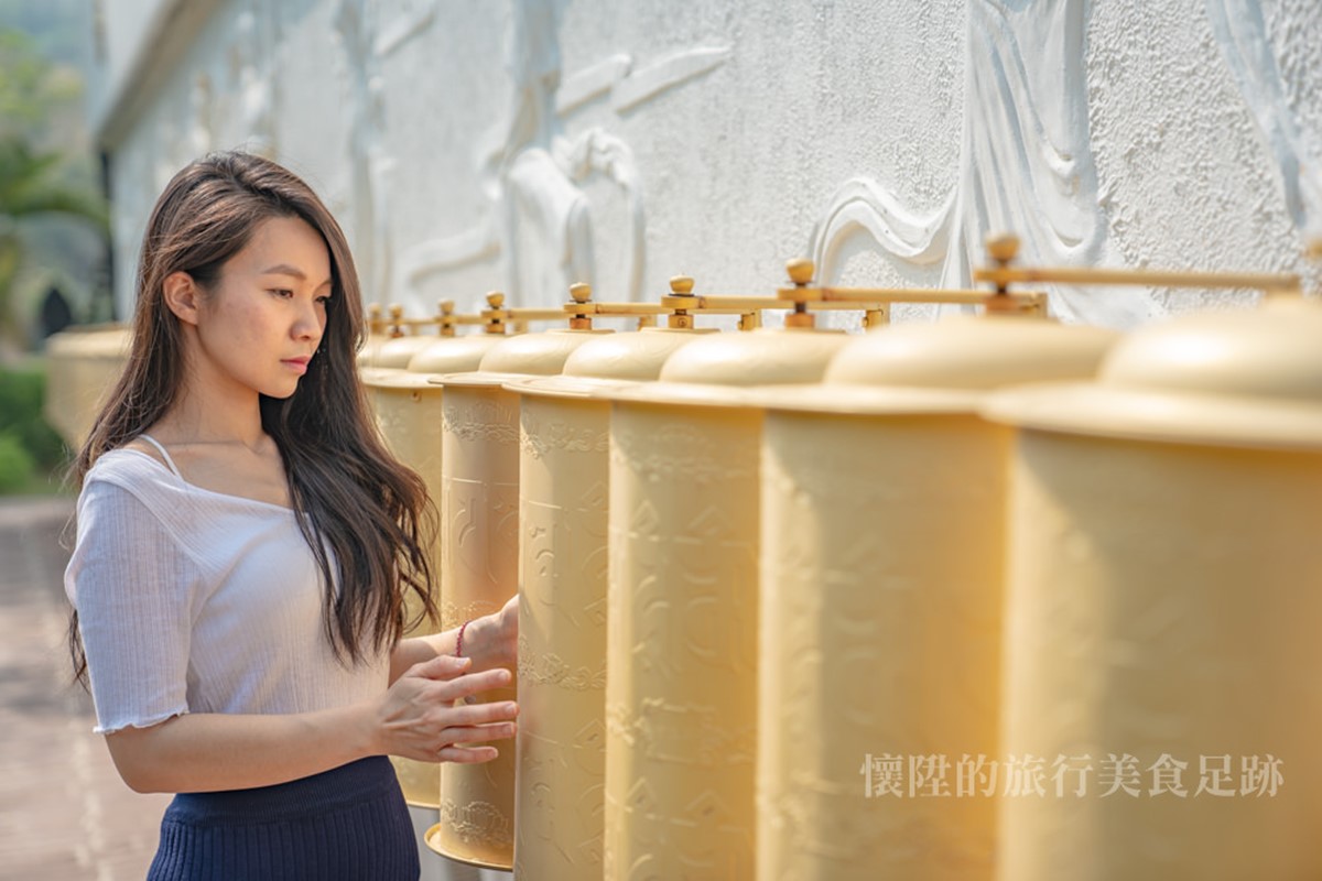 「舍利寶塔」旁邊有一整排金色轉輪，可透過順時針轉動的方式祈福。（圖／懷陞足跡提供）