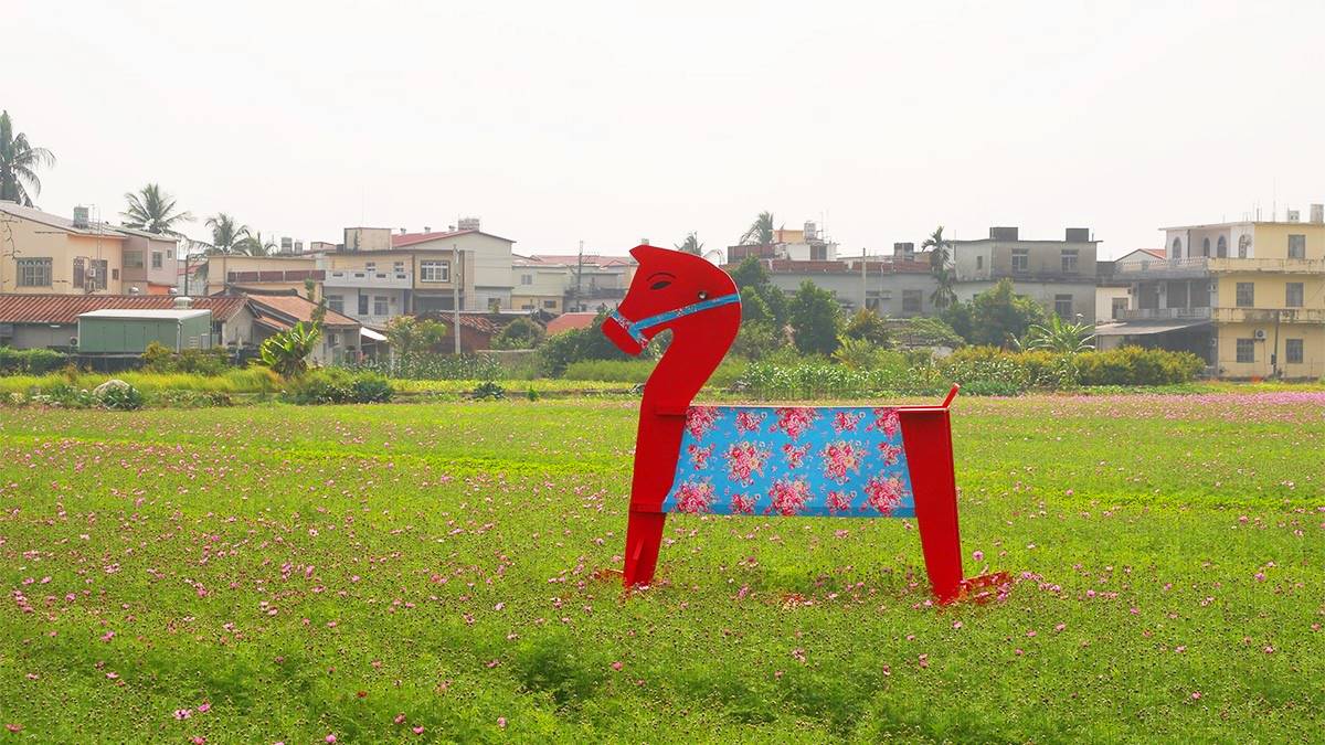 「幸福平安花區」花田裡藏有客家花布風格的搖搖馬可拍照。(圖/阿捷的打飯班提供)