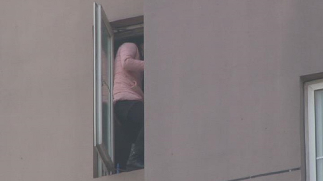 婦人一度站在窗台邊緣。(圖/翻攝自揚子晚報)