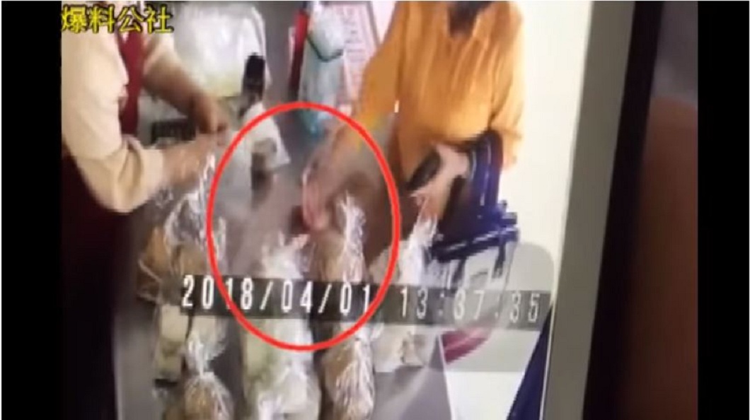 婦人趁店員在忙著打包之際,伸手將2百元準備收回。(圖/翻攝自YouTube)