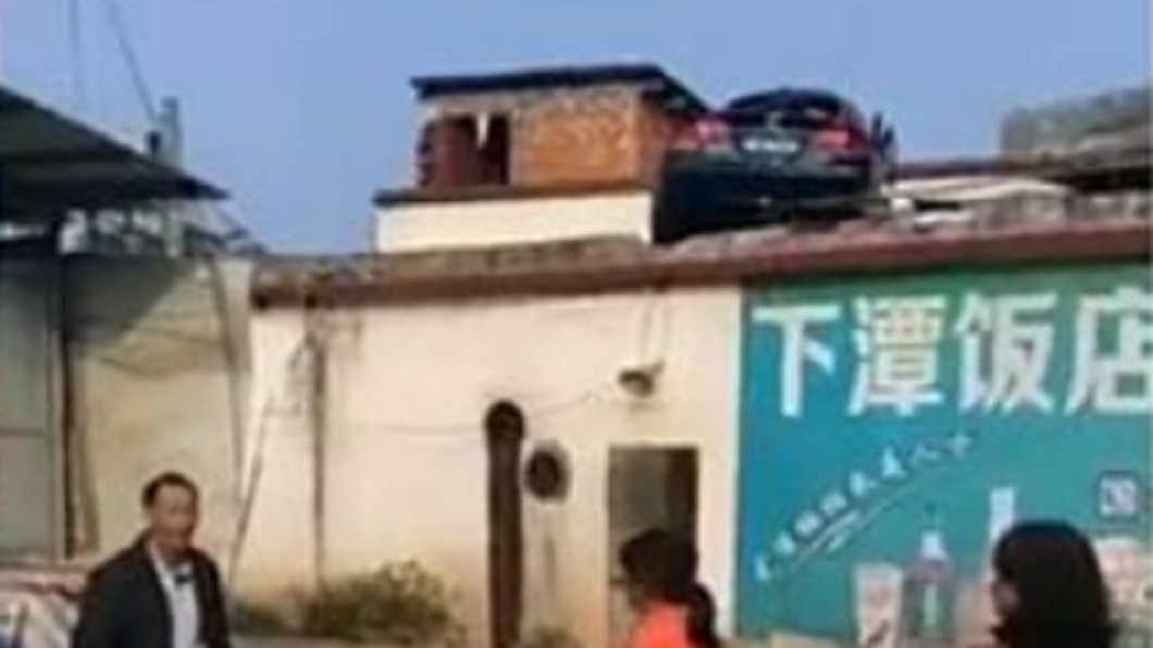 水泥牆變跳板!轎車過彎失控「直飛屋頂」
