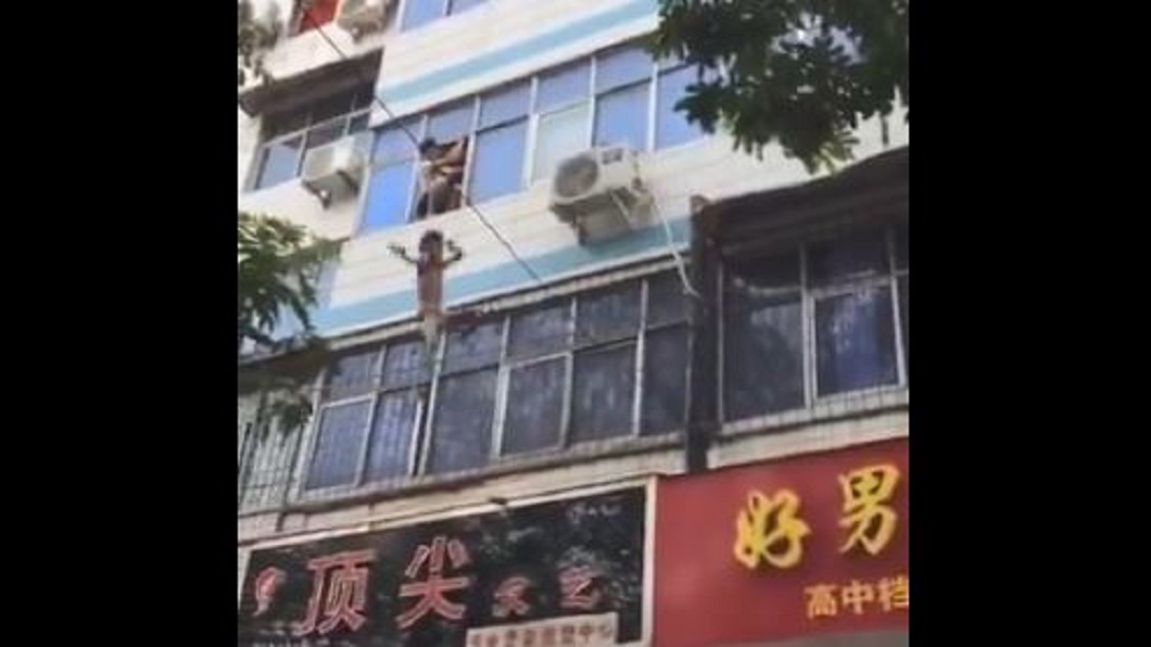太危險!火災受困高樓 路人接床單幫救童