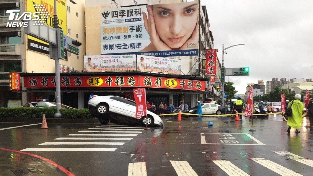 高雄市區今(29)日下午驚傳路面塌陷,一輛轎車整個卡在塌陷的大洞內動彈不得。(圖/TVBS)