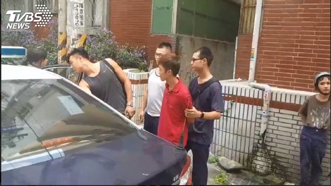 現場便衣刑警將砸雞蛋的男子上警車帶回偵訊。(圖/TVBS)