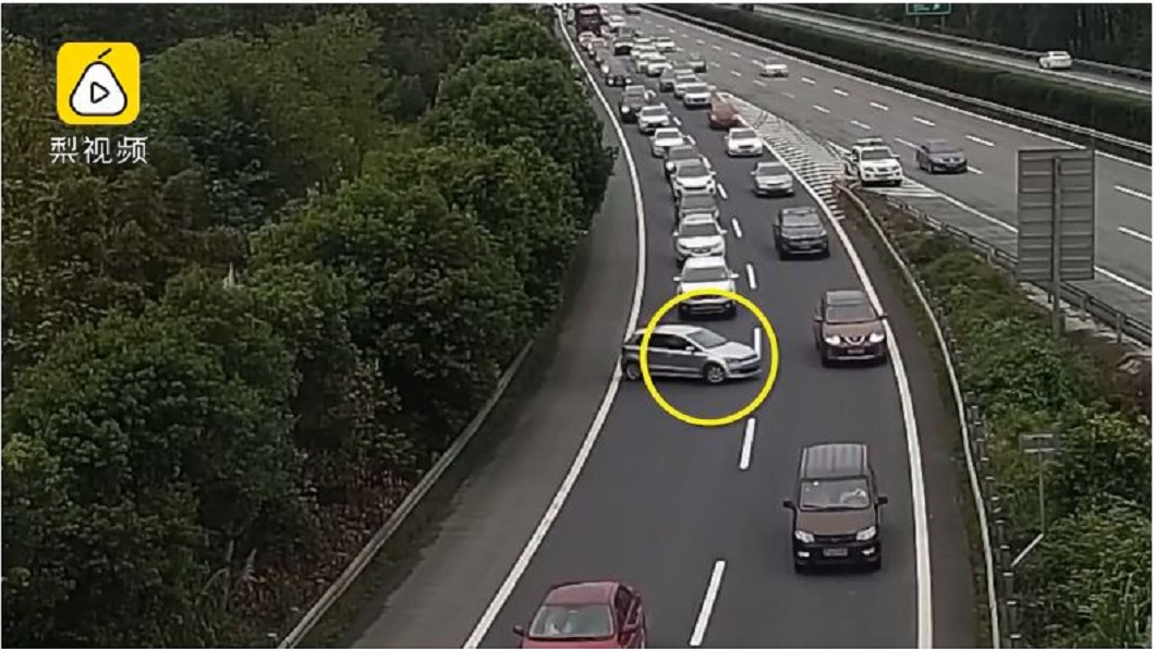 四川一名女駕駛直接在高速公路上無視後方長長車潮，直接在車道上迴轉。(圖／翻攝自梨視頻)