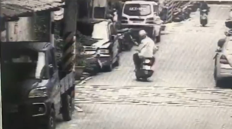 游男騎車行經金門街215巷時，從包包掉出一疊鈔票，還回頭看了一眼。／警方提供