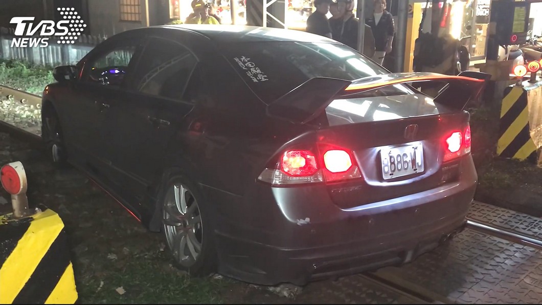 疑對向車遠燈刺眼! 轎車失控衝鐵軌卡住