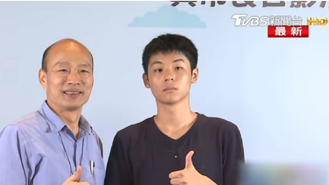 韓國瑜原本面露微笑地和男學生比讚合影。(圖／TVBS)