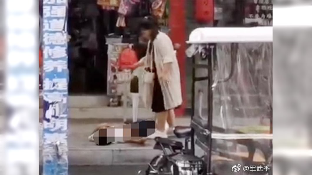 女子當街行兇之後，站在一旁不停甩手，想要把血甩掉。圖／翻攝軍武季微博