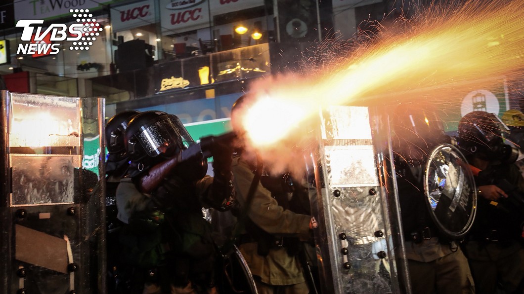 香港反送中運動31日自傍晚起上演一連串暴力抗爭場面,警民雙方對峙至入夜仍在持續,鎮暴警察晚間集結在灣仔一帶,整隊後發射催淚彈,強勢驅離示威民眾。圖/中央社