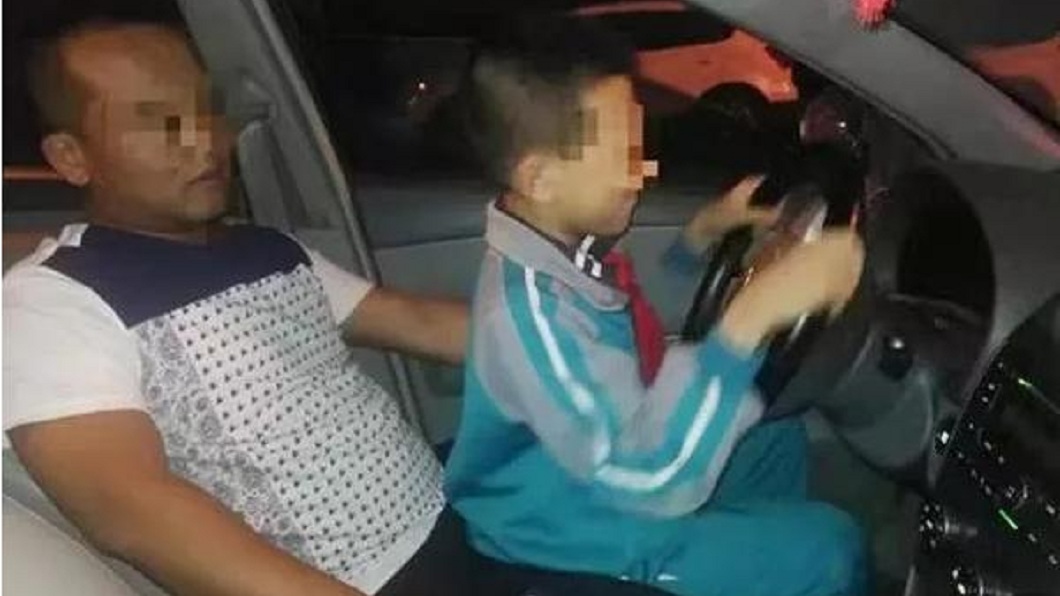 當時該名男童坐在父親大腿上握著方向盤「開車」,母親在副駕駛座拍攝還讚兒子是老司機。(圖/翻攝自微博)