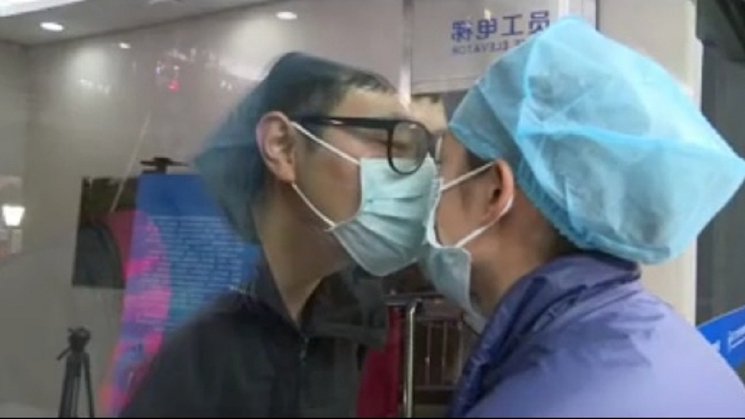 大陸一名護理師因投入第一線防疫工作,只能跟男友隔著玻璃門見面。(圖/翻攝自微博)