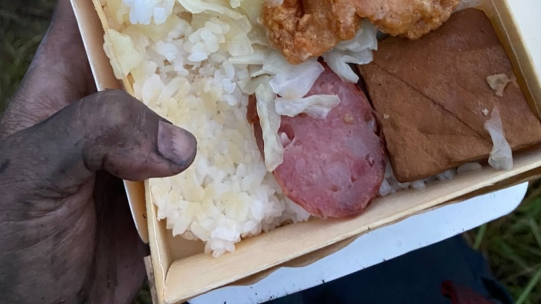 消防員用燻黑的手捧著便當。（圖／翻攝自新北消防發爾麵FB）