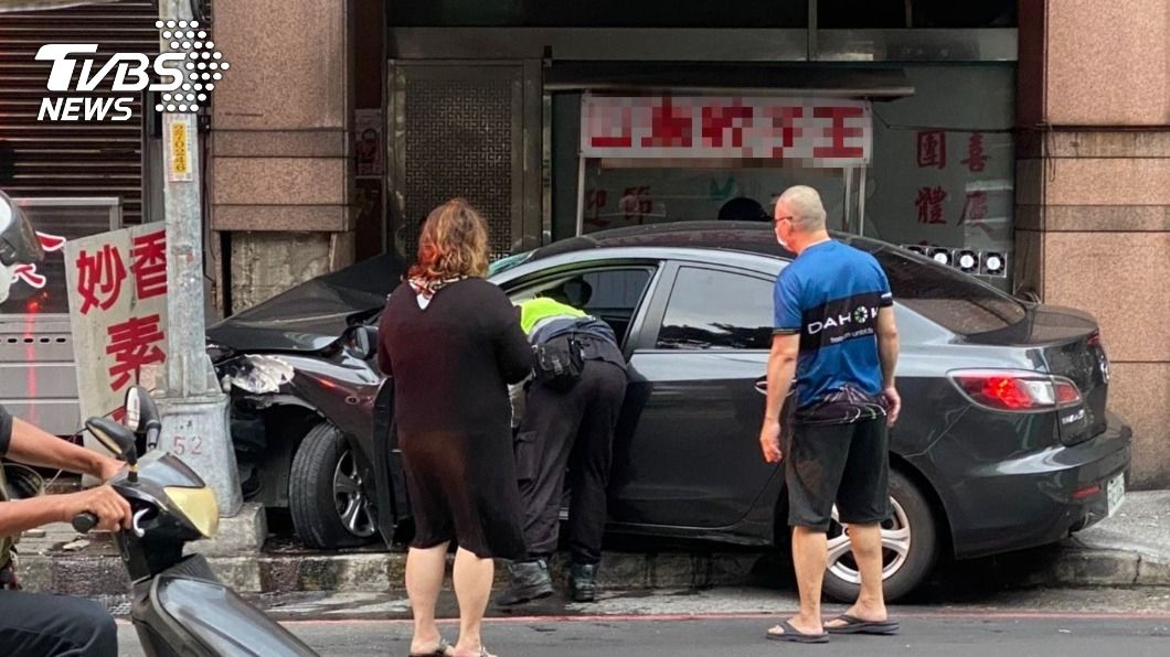 駕駛疑似車速過快直接撞進人行道,車頭卡在燈桿縫隙。(圖/TVBS)