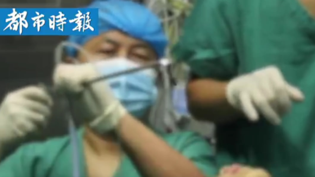 醫師從男童氣管中拔出蠕動水蛭。(圖/翻攝自微博/都市時報)