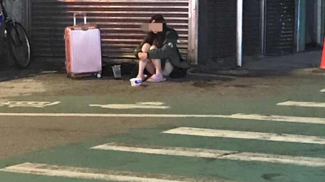 民眾發現這名年輕女子旁邊還放個行李箱,面前還有紙碗。(圖/翻攝自爆廢1公社)
