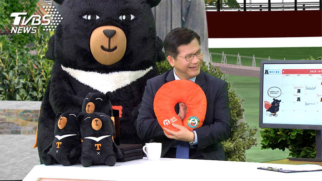 林佳龍推展觀光親力親為，上節目也不忘帶著觀光局的周邊商品，推薦給主持人莊開文和觀眾們。(圖／TVBS)
