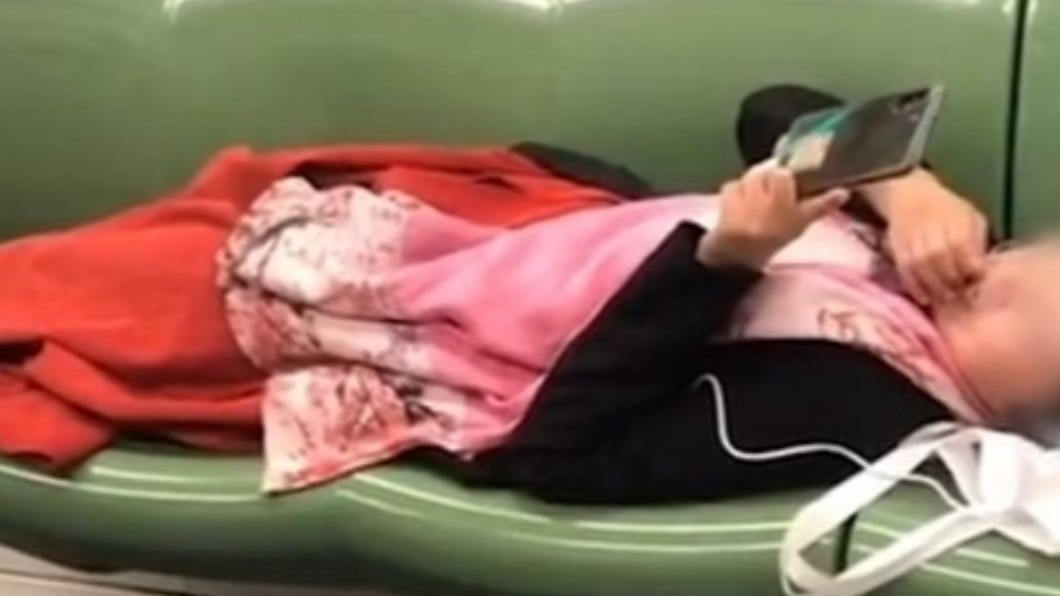女子躺下後竟旁若無人開始摳牙。(圖/翻攝自新民網)