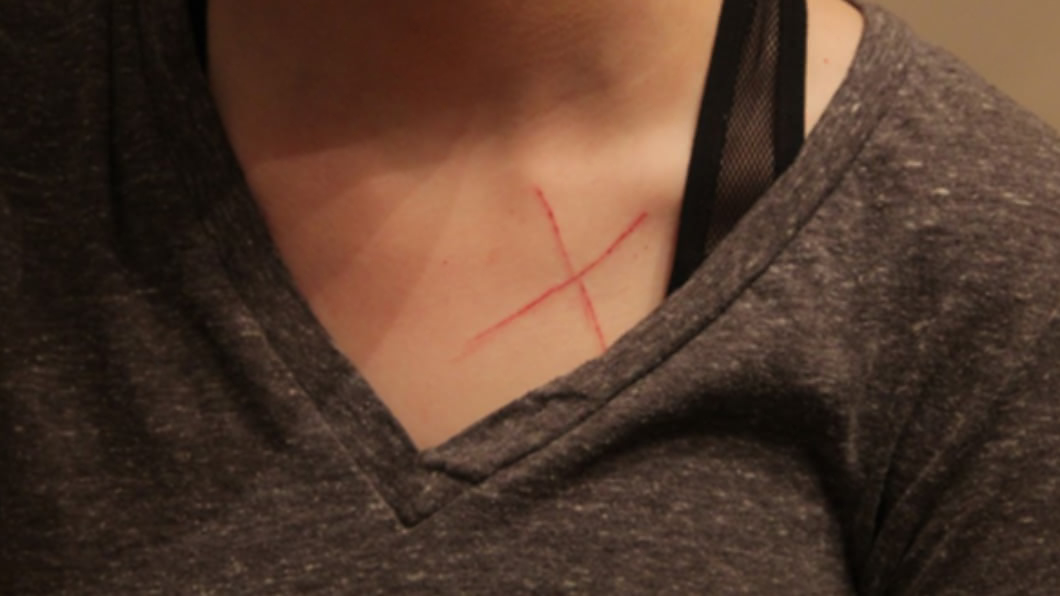 女子指控克里斯托佛硬闖家門並毆打她,在胸口留下X形刀痕。(圖/翻攝自《The Sun》)