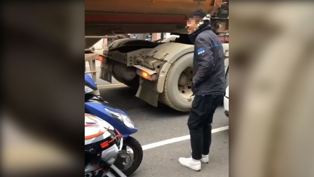影片拍攝者不斷出聲慫恿男子鑽車底。（圖／翻攝自臉書社團「爆料公社二社」）