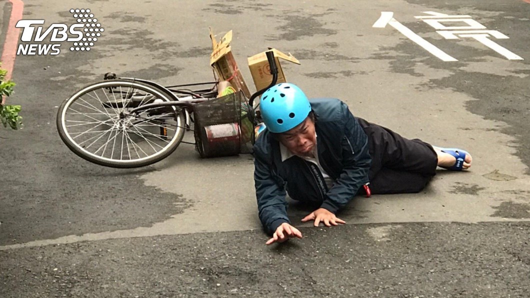 康康為MV摔倒跌坐在路邊。(圖/亞歷安傳播工作室提供)