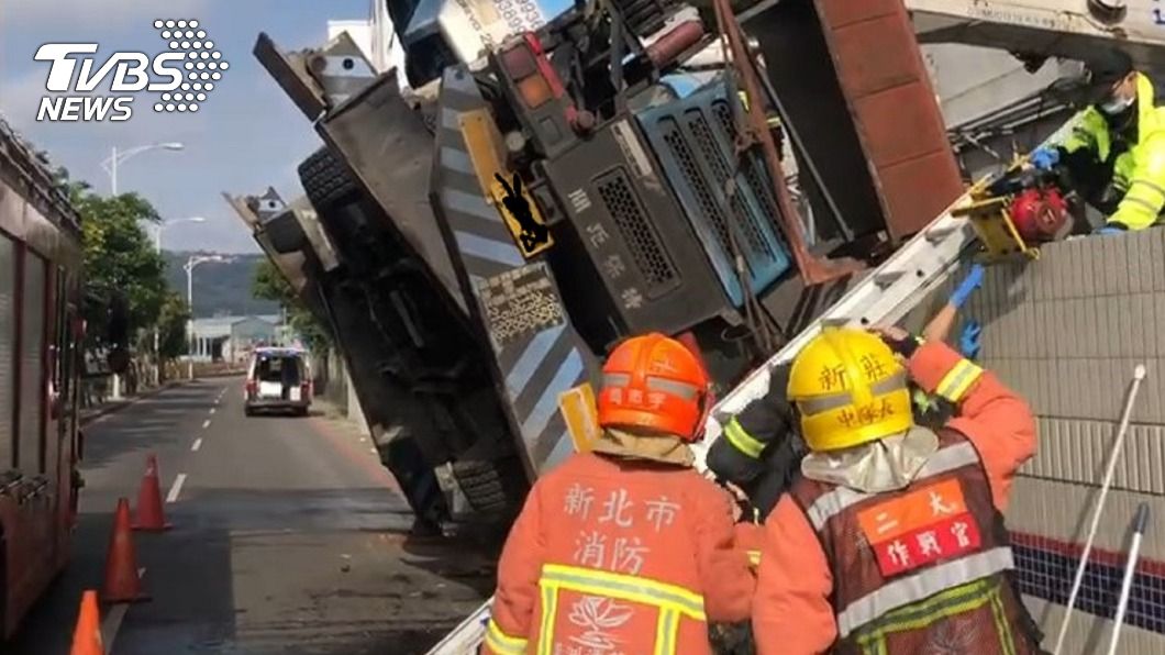 疑吊臂伸展過長車輛重心不穩側翻，工人當場墜落受傷送醫。（圖／中央社）