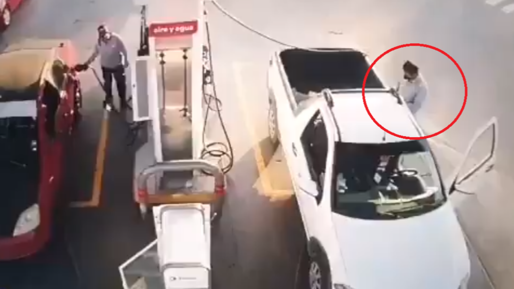 男子等待加油時,站在一旁滑手機。(圖/翻攝自QuePocaMadre_Mx twitter)