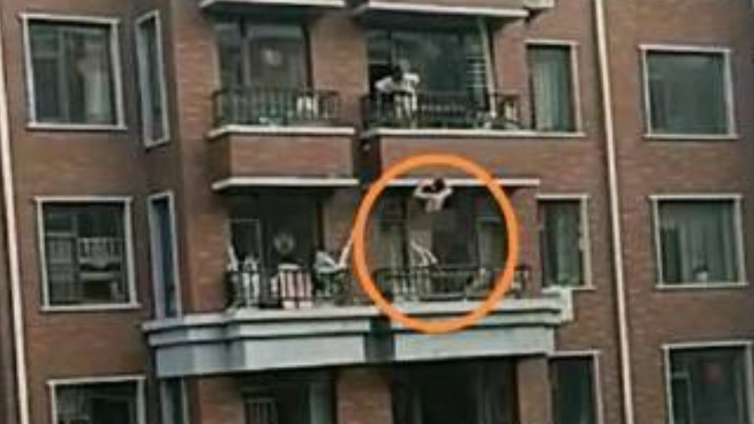 男子攀爬在陽台外緣,看起來十分危險。(圖/翻攝自微博)