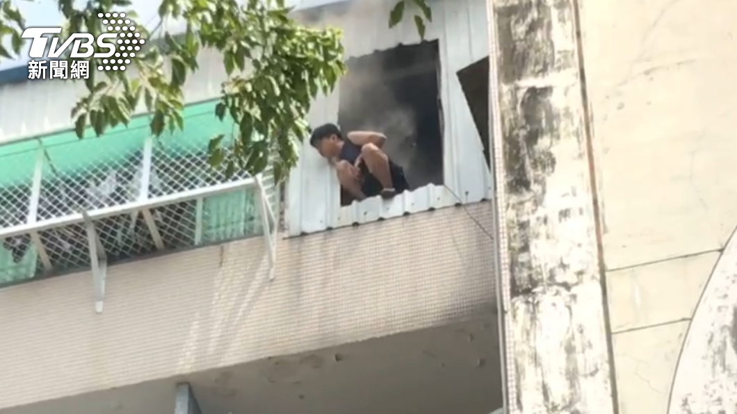 男子高掛陽台等待救援。(圖/TVBS)