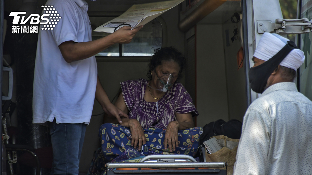 圖/一位72歲的婦女因為染疫造成呼吸困難,坐在救護車上接受供氧輔助,達志影像美聯社