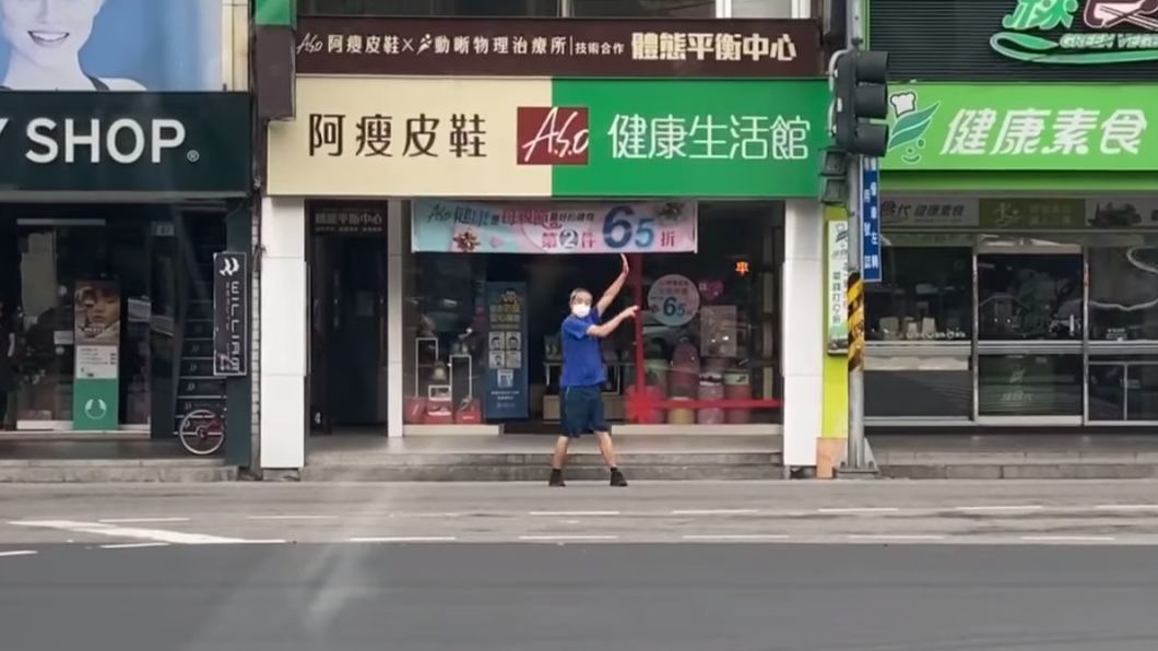 藍衣阿伯高舉雙手指揮交通。(圖/翻攝自路上觀察學院)