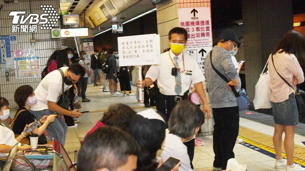 台鐵加派人員在月台舉牌，來回加強宣導防疫。（圖／中央社）