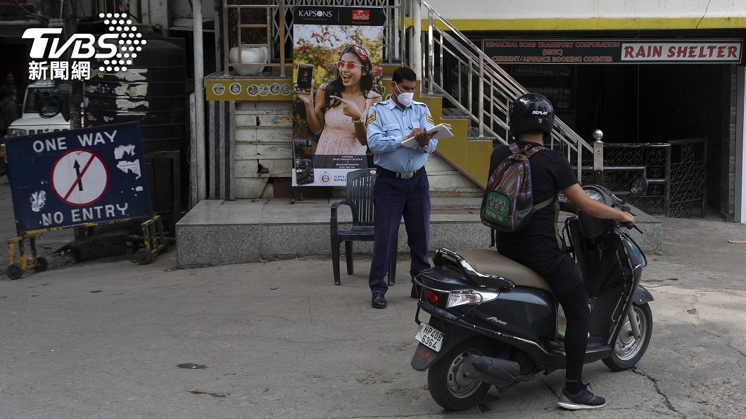 警方詢問摩托車騎士是否有出行許可(圖/達志影像美聯社)