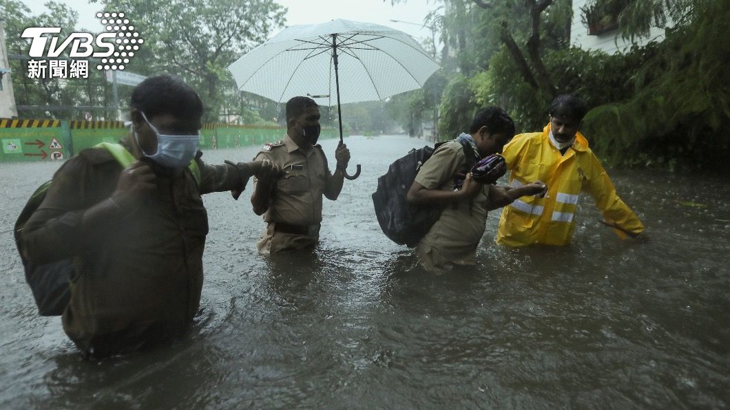 印度日前遭遇強烈颱風,多處地區淹水成災,當地警方協助民眾撤離。(圖/達志影像路透社)