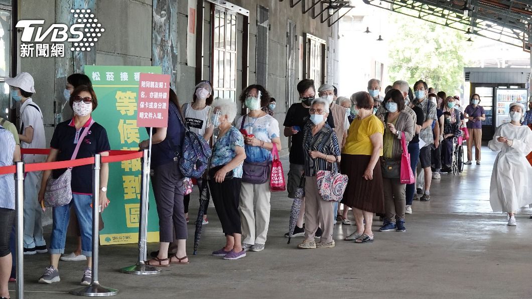 民眾在接種站外排隊,由於難以維持安全社交距離,讓部分民眾憂心群聚風險。(圖/中央社)