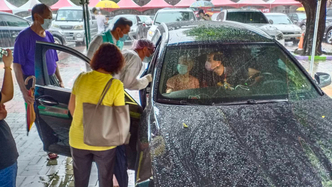 草湖國小快打站醫護替雨天行動不便的長者施打疫苗。(圖/台中市政府提供)