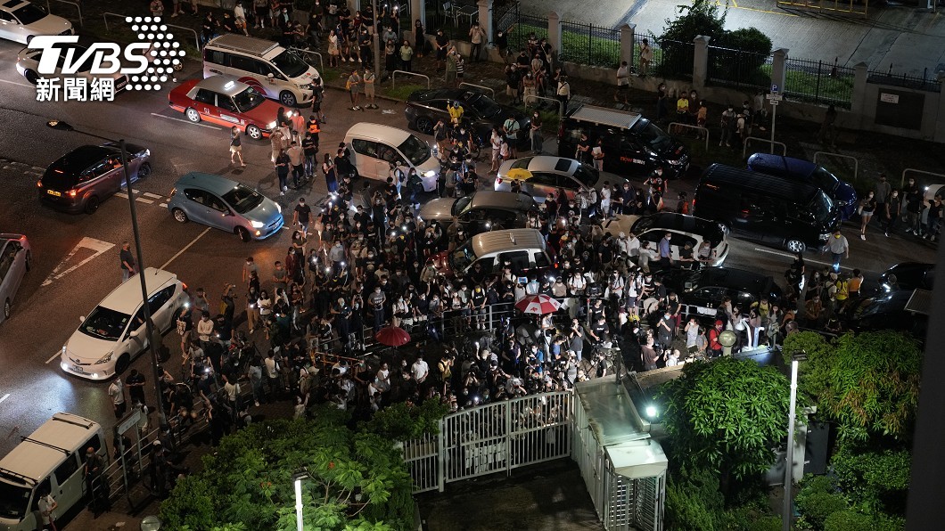許多讀者冒著夜雨,來到香港蘋果日報總部門外致意。(圖/達志影像美聯社)