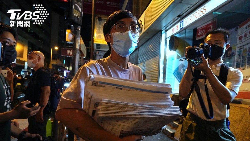 也有讀者捧著一疊報紙,準備分送給親朋好友。(圖/達志影像美聯社)