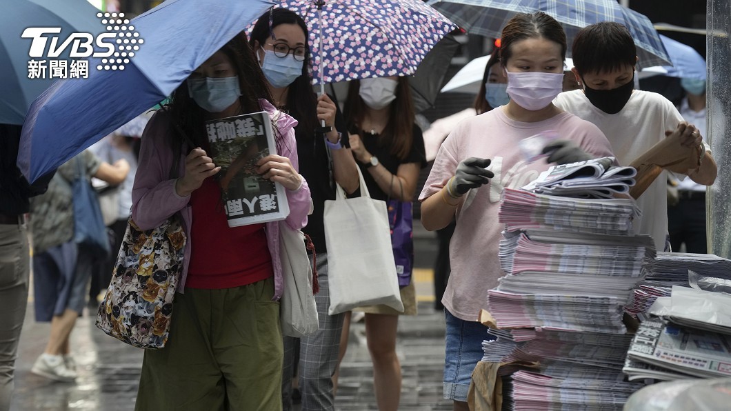 讀者們依序排隊購買,絲毫不受天雨影響。(圖/達志影像美聯社)