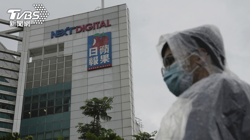 雖然是陰雨天氣,但是讀者依舊穿著雨衣站在報社大樓外表達支持。(圖/達志影像美聯社)