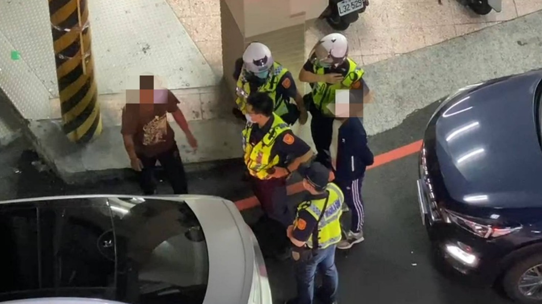 林男(咖啡色衣)與汽車駕駛(黑衣)爆口角,警方上前排解糾紛。(圖/翻攝自記者爆料網)