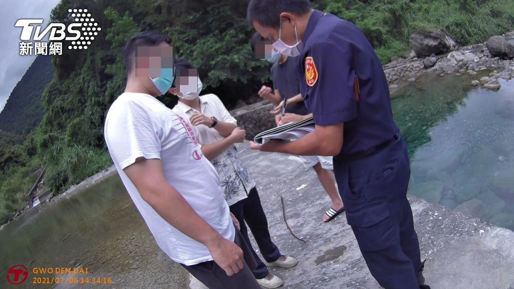 3名男子闖入砂婆礑溪戲水,違反防疫規定,員警當場取締。(圖/中央社)