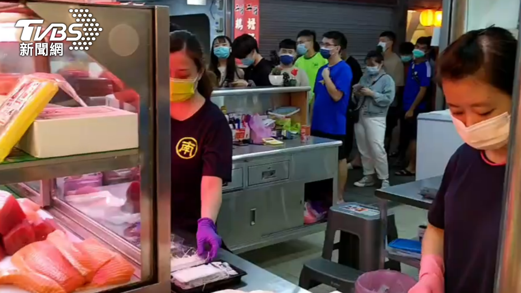 台中魚市場一間生魚片店今日凌晨大排長龍,老闆忙著準備食材。(圖/民眾提供)