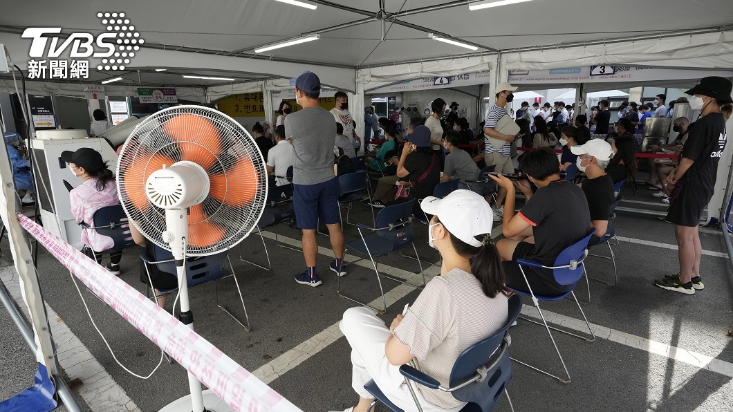 由於天氣炎熱,檢測區裡設置了強力風扇,讓民眾耐心等待。(圖/達志影像美聯社)