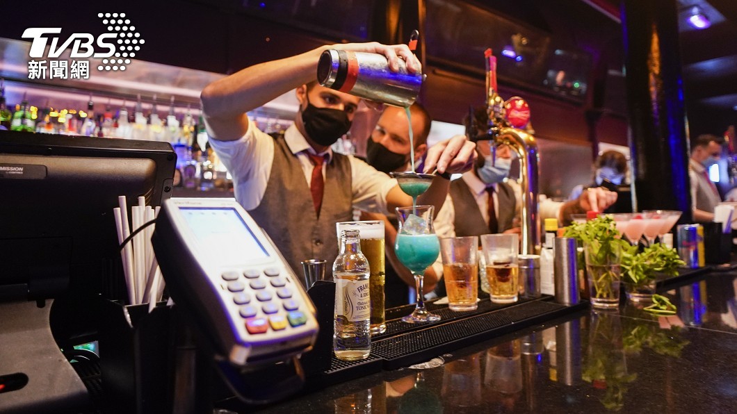 夜店吧台的調酒師還是戴著口罩為客人服務。(圖/達志影像美聯社)