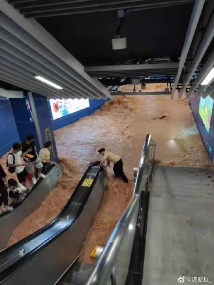 民眾站在手扶梯的扶手上等待撤離。(圖/翻攝自鍋斯拉微博)